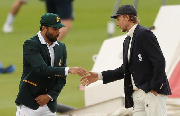 Cricket - First Test - England v Pakistan - Emirates Old Trafford, Manchester, Britain - August 5, 2020 Pakistan's Azhar Ali reacts as he and England's Joe Root shake hands after the coin toss before the start of play, as play resumes behind closed doors following the outbreak of the coronavirus disease (COVID-19) REUTERS/Lee Smith/Pool (REUTERS)
