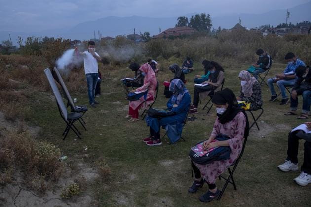 Muneer Alam, an engineer-turned-math teacher, sprays disinfectant before the start of an early morning outdoor class at Eidgah, a ground reserved for Eid prayers, in Srinagar, Jammu and Kashmir, Friday, July 18, 2020. Alam said the driving force to start the open-air classes was seeing children all around him depressed and anxious. The open-air classroom buzzes with students. Some sit on chairs. Others place themselves on rugged mats or on the ground. Social distancing is maintained. (AP) Muneer Alam, an engineer-turned-math teacher, sprays disinfectant before the start of an early morning outdoor class at Eidgah, a ground reserved for Eid prayers, in Srinagar, Jammu and Kashmir, Friday, July 18, 2020. Alam said the driving force to start the open-air classes was seeing children all around him depressed and anxious. The open-air classroom buzzes with students. Some sit on chairs. Others place themselves on rugged mats or on the ground. Social distancing is maintained. (AP)