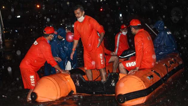 National Disaster Response Force (NDRF) personnel rescue passengers from a local train stranded between Masjid Bunder and Byculla stations on the Central line, during heavy rain, in Mumbai.(PTI)
