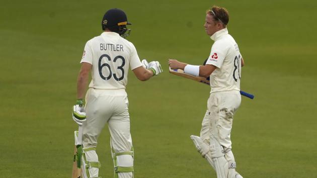 England's Jos Buttler, left, and Ollie Pope leave the filed at the end of the second day of the first cricket Test match between England and Pakistan at Old Trafford. (AP)