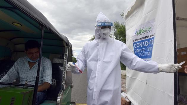 A health worker takes a sample for Covid-19 tests at a drive through testing facility near Sanjay Van in New Delhi on August 6. Life has cautiously returned to the streets of the capital of New Delhi and financial hub Mumbai, which appear to have passed their peaks, AP reported. (Sanjeev Verma / HT Photo)