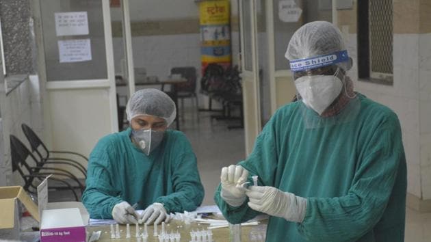 Health workers seen during coronavirus sample testing at MMG District Hospital in Ghaziabad on August 04, 2020.(Sakib Ali/HT Photo)
