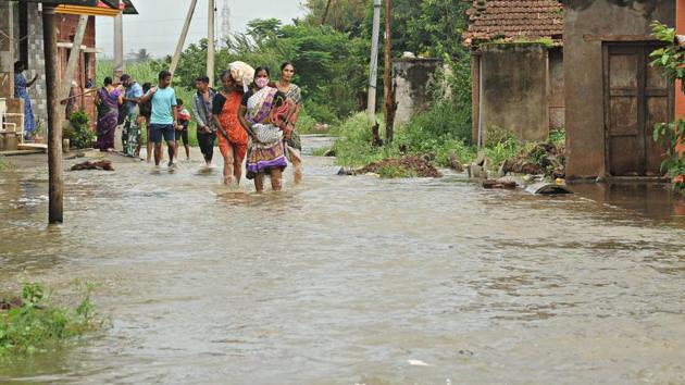 Residents of Chikhali village, some wearing face masks wade through a water logged road as they head to safer ground, in Kolhapur on August 6. According to the HT report, India’s focus of the battle against Sars-Cov-2 now needs to shift to the hinterland and the peninsula, both high population density regions with, in the case of the former, significant rural populations and relatively inadequate health care systems. (Anil Velhal / HT Photo)