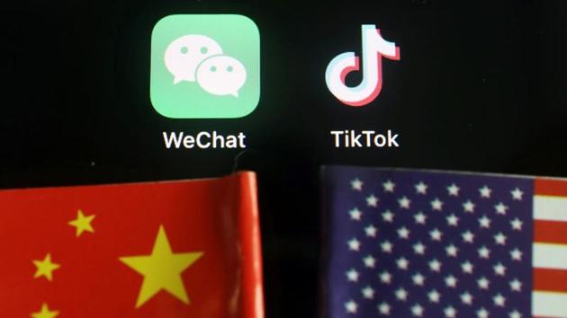 The messenger app WeChat and short-video app TikTok are seen near China and US flags. (REUTERS) The messenger app WeChat and short-video app TikTok are seen near China and US flags. (REUTERS)
