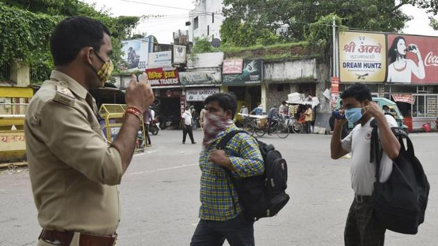A police personnel direct people to wear masks at Qaiserbagh in Lucknow on August 6. Andhra Pradesh, Karnataka, Uttar Pradesh, West Bengal and Bihar together were responsible for less than 19% of cases before July 16 when India hit the million-mark. (Dheeraj Dhawan / HT Photo)
