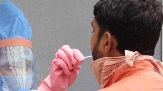 A health worker collects swabs for rapid testing in Hindpirhi locality, a coronavirus containment zone in Ranchi.(HT photo)