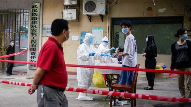 Medical workers in protective suits conduct nucleic acid testings for residents at a residential compound in Wuhan.(Reuters File Photo) Medical workers in protective suits conduct nucleic acid testings for residents at a residential compound in Wuhan.(Reuters File Photo)