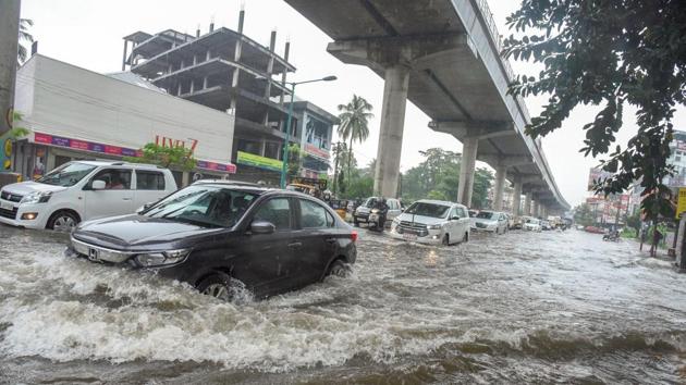 Vehicles ply on a waterlogged road after heavy rains in Kochi, on August 7. The IMD on August 7, declared a red alert for extremely heavy rainfall in Idukki, Malappuram and Wayanad districts and orange alert in five other districts of Kerala. (PTI)