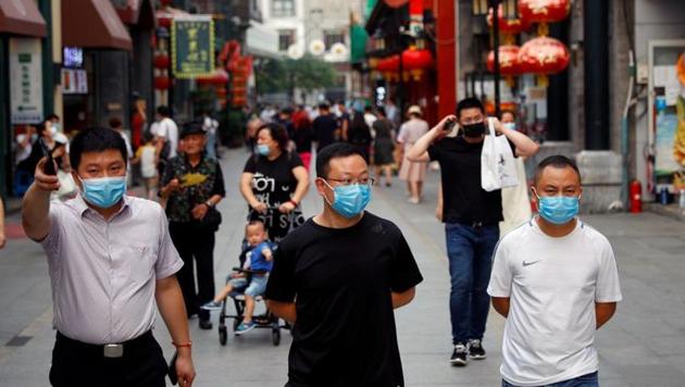 People wear protective masks as they walk in a shopping street following the outbreak of the coronavirus disease (COVID 19) in a historic part of Beijing, China.(REUTERS FIle)