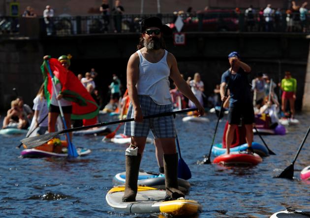 Participants make their way on the Griboyedov Canal during the Fontanka-SUP stand up paddle boarding festival in Saint Petersburg, Russia August 8, 2020. (REUTERS)