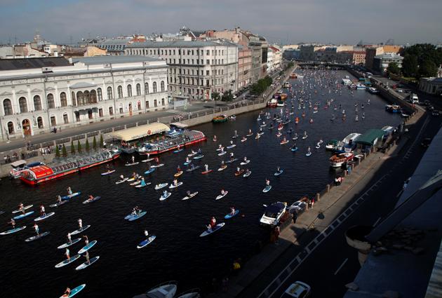 Participants make their way on the Fontanka river during the Fontanka-SUP stand up paddle boarding festival in Saint Petersburg, Russia August 8, 2020. (REUTERS)