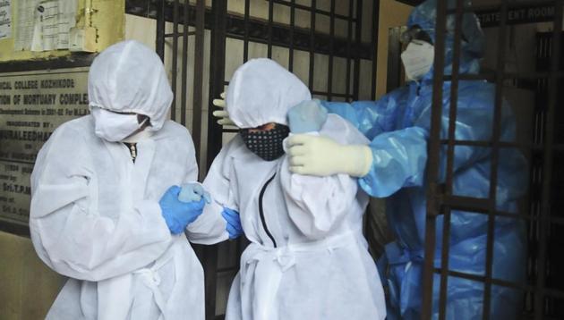 A woman (center) is assisted out of a morgue after taking a final look at the body of her husband Sudheer Warrieth, who died in Friday's plane accident in Kozhikode in Kerala . The deceased was confirmed Covid-19 positive.(AP) A woman (center) is assisted out of a morgue after taking a final look at the body of her husband Sudheer Warrieth, who died in Friday's plane accident in Kozhikode in Kerala . The deceased was confirmed Covid-19 positive.(AP)
