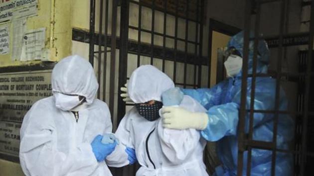 A woman, center, is assisted out of a morgue after taking a final look at the body of her husband Sudheer Warrieth, who died in Friday's plane accident in Kozhikode, Kerala, Saturday, Aug. 8, 2020. The deceased was confirmed Covid-19 positive. The special evacuation flight bringing people home to India who had been trapped abroad because of the coronavirus skidded off the runway and split in two while landing in heavy rain killing more than a dozen people and injuring dozens more. (AP Photo/C.K.Thanseer)(AP)