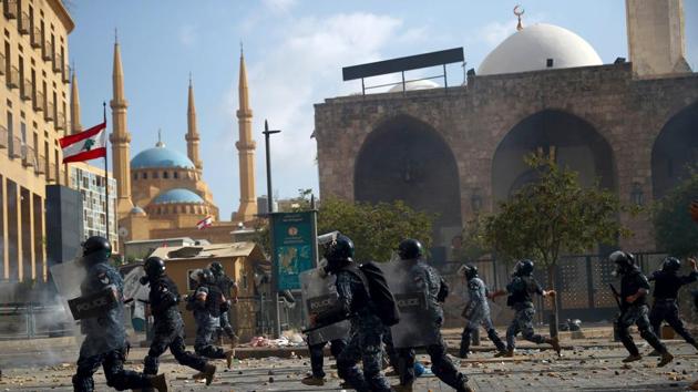 Riot police members run after demonstrators during a protest near the parliament building following Tuesday's blast, in Beirut, Lebanon.(REUTERS) Riot police members run after demonstrators during a protest near the parliament building following Tuesday's blast, in Beirut, Lebanon.(REUTERS)