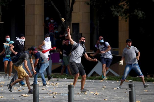 Demonstrators hurl stones during a protest near the parliament building following Tuesday's blast, in Beirut, Lebanon August 8, 2020. (REUTERS) Demonstrators hurl stones during a protest near the parliament building following Tuesday's blast, in Beirut, Lebanon August 8, 2020. (REUTERS)
