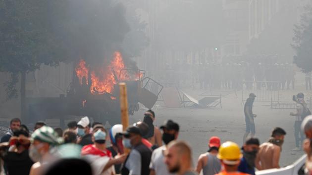 A vehicle burns as demonstrators try to break through a barrier to get to the parliament building during a protest following Tuesday's blast, in Beirut, Lebanon. (REUTERS) A vehicle burns as demonstrators try to break through a barrier to get to the parliament building during a protest following Tuesday's blast, in Beirut, Lebanon. (REUTERS)