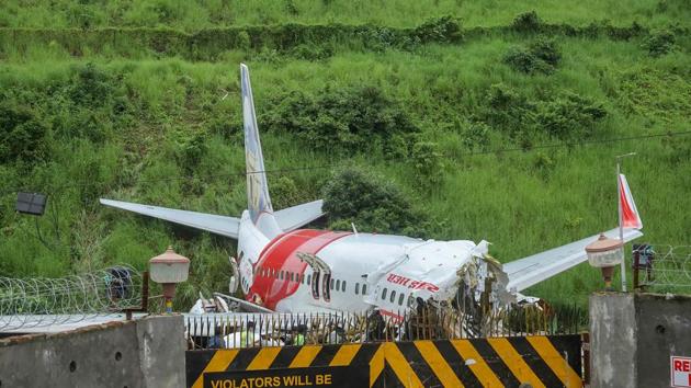 Security personnel stand guard near the mangled remains of an Air India Express flight, en route from Dubai, after it skidded off the runway while landing on Friday night, at Karippur in Kozhikode on August 08, 2020. (PTI Photo) Security personnel stand guard near the mangled remains of an Air India Express flight, en route from Dubai, after it skidded off the runway while landing on Friday night, at Karippur in Kozhikode on August 08, 2020. (PTI Photo)