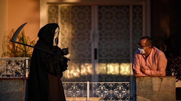 A man looks at a person dressed as the Grim Reaper to raise awareness against measures to prevent the spread of the new coronavirus in Formiga on August 7. The coronavirus outbreak in Brazil is showing no sign of slowing as it enters its sixth month. Infections have accelerated in recent weeks in the countryside as well as inland regions and areas where the virus was late arriving. (Douglas Magno / AFP) A man looks at a person dressed as the Grim Reaper to raise awareness against measures to prevent the spread of the new coronavirus in Formiga on August 7. The coronavirus outbreak in Brazil is showing no sign of slowing as it enters its sixth month. Infections have accelerated in recent weeks in the countryside as well as inland regions and areas where the virus was late arriving. (Douglas Magno / AFP)