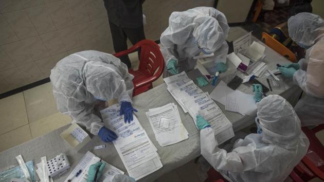 Health workers seen shuffling through documents while conducting Covid-19 rapid antigen tests at Asha Hall in Govandi, Mumbai on August 6. Maharashtra on August 8 reported its highest single-day jump of 12,822 new coronavirus disease (Covid-19) cases, taking the state’s tally of infections past the 500,000 mark. (Pratik Chorge / HT Photo)