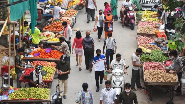Vendors and customers are seen wearing face masks as a precaution against the coronavirus (Covid-19) disease in Pandav Nagar, New Delhi on Friday.(Raj K Raj/HT Photo)