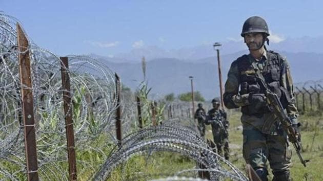 An Indian Army soldier patrols on the fence near the India-Pakistan LoC in Chakan-da-Bagh area near Poonch.(Gurinder Osan/HT File Photo)