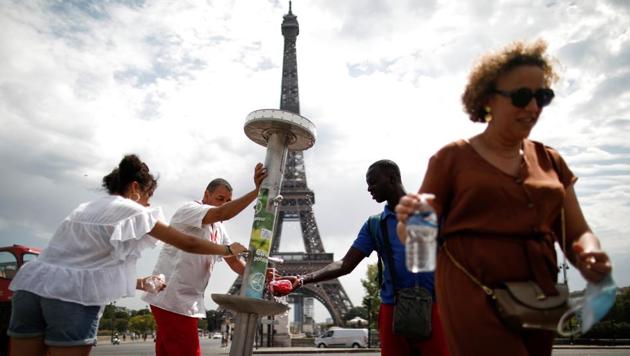 Customers wearing protective face masks strolling close from Chanel store  on the Champs Elysee avenue on May 11, 2020 in Paris, France. France began  a gradual easing of its lockdown measures and