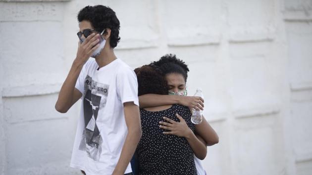 Relatives grieve while attending the funeral service of a relative who died of Covid-19, at the Nova Iguacu municipal cemetery in Nova Iguacu on August 7. The contagion has cast a harsh light on Brazil’s inequalities, with the virus wreaking particular havoc on the country’s favelas and hitting black populations especially hard. The country’s indigenous Amazon populations have also been hard hit. (Silvia Izquierdo / AP) Relatives grieve while attending the funeral service of a relative who died of Covid-19, at the Nova Iguacu municipal cemetery in Nova Iguacu on August 7. The contagion has cast a harsh light on Brazil’s inequalities, with the virus wreaking particular havoc on the country’s favelas and hitting black populations especially hard. The country’s indigenous Amazon populations have also been hard hit. (Silvia Izquierdo / AP)