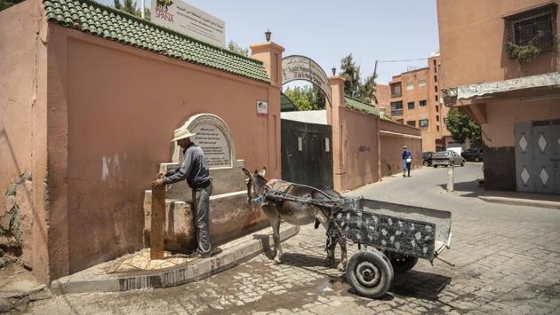 A merchant stops his donkey cart at a water fountain on a hot summer day in Marrakech, Morocco, Wednesday, July 22, 2020. (AP Photo/Mosa'ab Elshamy)