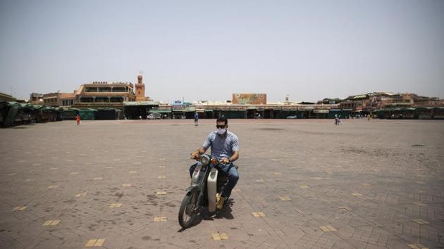 A motorcyclist rides his bike in the usually bustling but currently empty Marrakech landmark of Jemma el-Fnaa, Morocco, Wednesday, July 22, 2020. (AP Photo/Mosa'ab Elshamy)