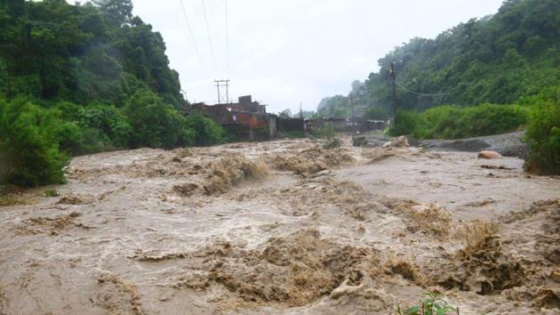 A seasonal river overflowing in Dehradun on Monday after continuous rainfall.(Paras Negi/HT Photo)