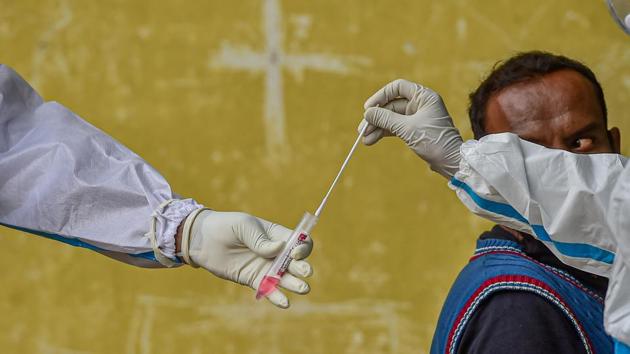 Health workers in PPE kit store a collected sample in a test-tube for COVID-19 testing in Bengaluru on August 7. A rise of 62,064 new cases of Covid-19 cases in the previous 24 hours has pushed the tally of coronavirus infections to 2,215,075, according to Union health ministry’s bulletin on August 10. (Shailendra Bhojak / PTI)