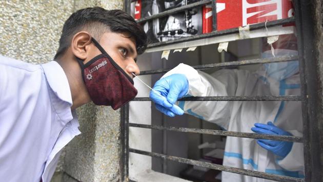 A health worker collects a swab sample from a man in New Delhi on August 7. India has performed about 25 million tests since January 22 when Covid-19 testing started with one lab at Indian Council of Medical Research’s (ICMR) National Institute of Virology in Pune, HT reported. As on August 9, India has 1,402 labs -- 940 government and 462 private labs -- approved to perform Covid-19 testing across the country. (Sonu Mehta / HT Photo)