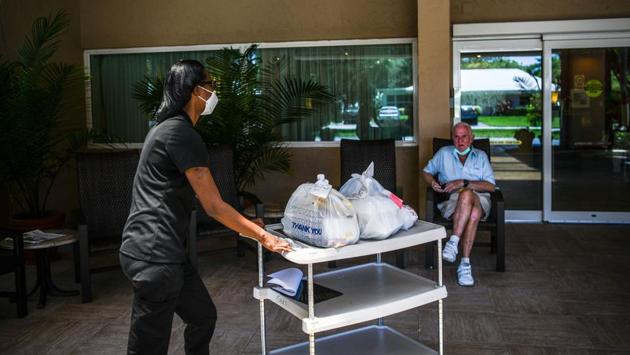 A worker delivers food in John Knox Village, a retirement community north of Miami on August 7. The US added its latest million cases in just over two weeks. As cases and deaths slowed in the sunbelt states of Florida and Arizona, White House economic adviser Larry Kudlow argued the US is making inroads against the virus’s spread. (Chandan Khanna / AFP)