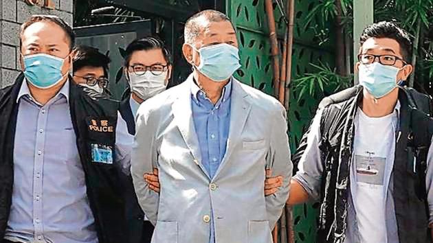 Anti-Beijing media tycoon Jimmy Lai (centre), who founded the newspaper Apple Daily, is arrested at his home in Hong Kong.