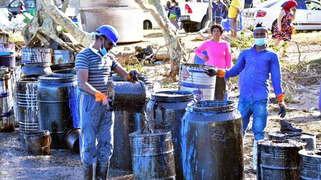 A man collects leaked from the ship at Riviere des Creoles in Mauritius on August 10. According to an AFP report, divers have reported fresh cracks in the hull, while creaking sounds from the vessel could be heard from the southeast shore, where a major clean-up operation is underway to remove treacly sludge coating miles of Mauritius’ previously unspoiled coastline. (Dev Ramkhelawon / L'Express Maurice / REUTERS)