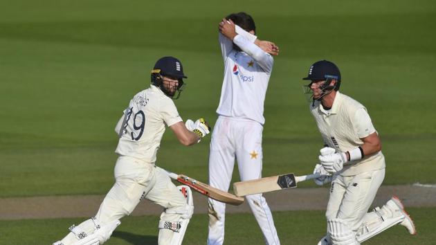 Pakistan's Shaheen Afridi, center, reacts as England's Chris Woakes, left, and Stuart Broad, right, run.(AP)