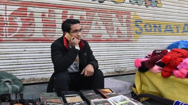 A man speaks on a mobile phone at a marketplace in Srinagar, Jammu and Kashmir.(Waseem Andrabi / Hindustan Times)