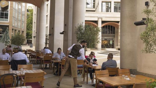 A waiter serves diners outside a restaurant at The London Stock Exchange in London, UK.(Bloomberg)