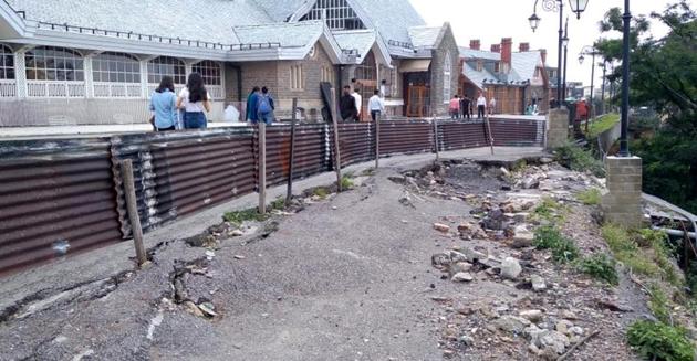 Residents walking past the portion of the Ridge in Shimla on Wednesday that has been barricaded as it’s sunk further this monsoon.(Deepak Sansta/HT)
