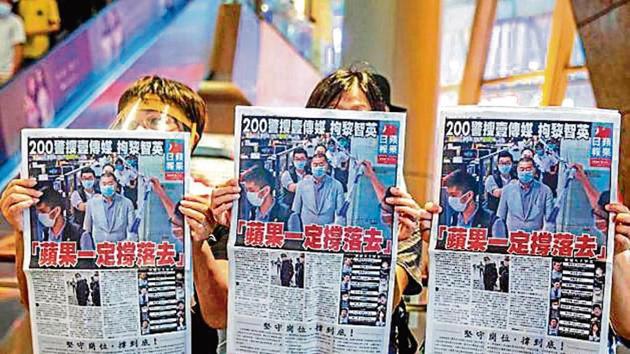 People hold up copies of Apple Daily as they protest for press freedom inside a mall in Hong Kong on Tuesday. People hold up copies of Apple Daily as they protest for press freedom inside a mall in Hong Kong on Tuesday.