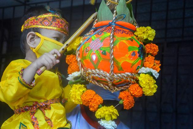 Thane: A child dressed as Lord Krishna tries to break an earthen pot (Dahi Handi) on the occasion of Krishna Janmashtami festival, in Thane, Wednesday, Aug 12, 2020. (PTI)