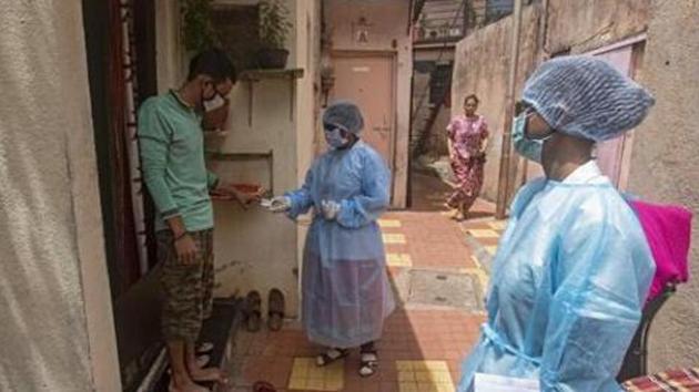 Health workers during a door-to-door screening for coronavirus in a slum near Dandekar bridge in Pune.(Pratham Gokhale/HT Photo) Health workers during a door-to-door screening for coronavirus in a slum near Dandekar bridge in Pune.(Pratham Gokhale/HT Photo)