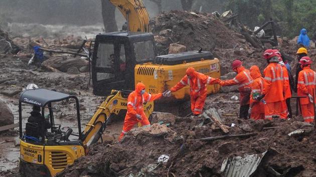 Rescue workers look for survivors at the site of a landslide during heavy rains in Idukki, Kerala.(Reuters)