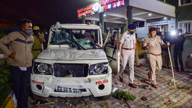 Police stand guard after a mob vandalised a police station following a social media post by a relative of a MLA, in Bengaluru.(PTI)