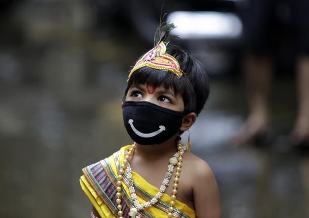 A boy dressed as Hindu god Krishna wears a mask as a precaution against the coronavirus during Janmashtami festival celebrations in Mumbai, India, Wednesday, Aug.12, 2020. The festival marks the birth anniversary of Krishna. (AP)