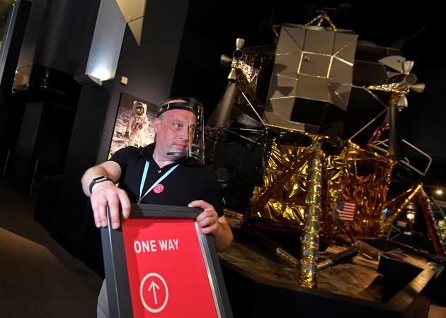 Jon Kaddish, Visitor Experience Operations Manager, holds social distancing signage near a replica of the Apollo 11 Lunar Module, ahead of the reopening of the Science Museum, after lockdown restrictions were eased following the outbreak of the coronavirus disease (COVID-19), London, Britain, August 10, 2020. (REUTERS)