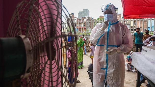 A health worker cools off in front of a pedestal fan while collecting swab samples to test for Covid-19 at Mehrauli in New Delhi on August 10. Between August 12 and 13 morning, India recorded its highest single-day coronavirus disease (Covid-19) recoveries so far, in excess of 56,000, taking the overall recovery rate to 70%, HT reported. (Amal KS / HT Photo)
