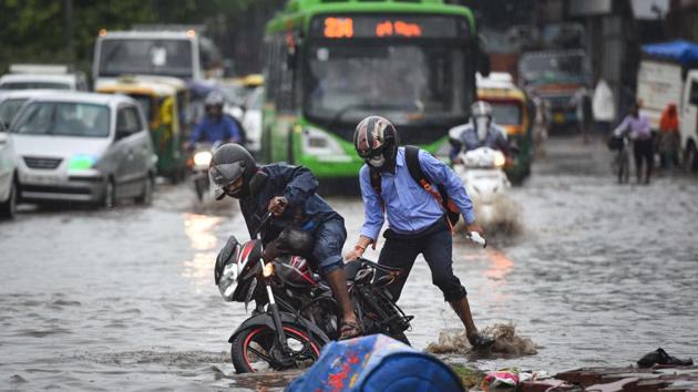 A motorist tries to wade through a waterlogged road following heavy rain at Zakhira in New Delhi on August 13. The downpour also brought down the rain deficiency in Delhi. Until August 12 evening, the Safdarjung observatory had recorded 72 per cent less rainfall than normal in August, the lowest in 10 years, PTI reported quoting Indian Metrological Department’s (IMD) bulletin.  (Sanchit Khanna / HT Photo) 