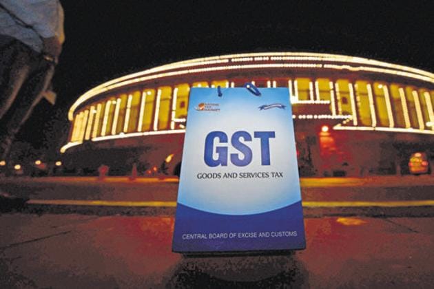 A Goods and Services Tax (GST) placard is seen in front of the illuminated Parliament building in New Delhi in this file photo.(PTI Phoro)