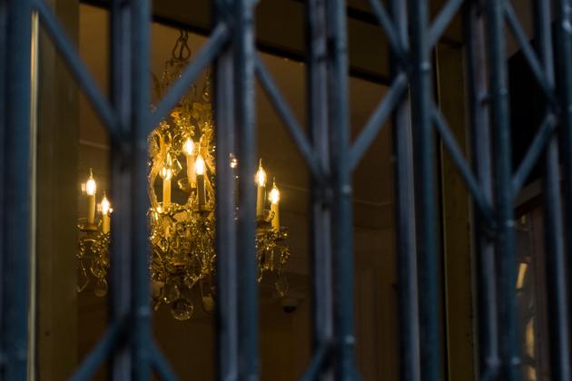 A chandelier hangs illuminated behind shutters in the closed Le Bristol hotel, one of the 12 high-end hotels in Paris that are classified as palaces, ahead of reopening, in Paris, France, on Wednesday, Aug. 12, 2020. As the capital of the world’s No. 1 tourist destination, Paris has no shortage of hotels for all tastes and wallets, from the dumpy dive to the pillared palace, where a single night can set you back as much as 30,000 euros ($35,000). (Bloomberg)